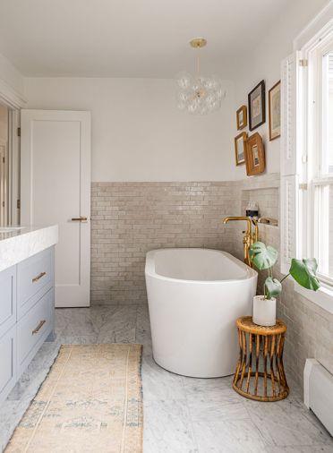 Signature Hardware tub warmed by handmade Zia tile and Waterworks Brass plumbing. The Light Factory chandelier draws eye toward view.