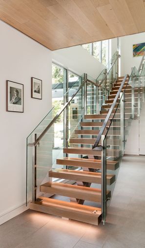 A custom staircase with white oak treads inset with LED lights, a stringer by Splice Welding and Design, and railing system by Missoula Blacksmith, lends airiness to the room.