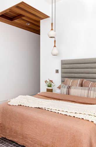 In the guest room, an Article bed sits with Room and Board pendants.