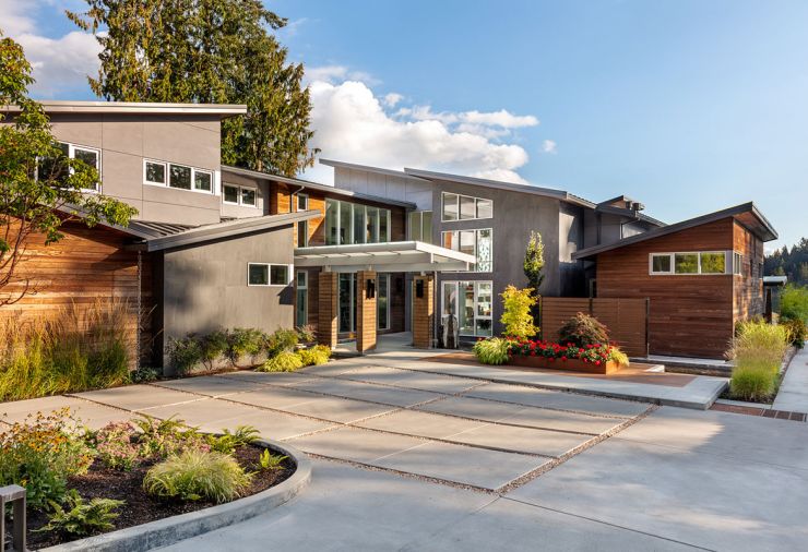 The entry court at the front of the house is an open-air affair, with artful landscaping, plants, water elements, and illuminated by Tech Lighting Model lighting. On the exterior façade, there are Fleetwood windows and cedar siding, and a privacy screen conceals the outdoor shower. Ribbons of high windows tucked under the flaring rooflines bring in light, but don’t sacrifice privacy.