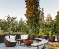 Furniture and planters are free-floating, including groundcover and sedums from Blooming Nursery styled on moveable trays. The pavers are a pedestal design that allows gas, lighting, and irrigation to flow hidden underneath. The planters cleverly hide the propane tanks for the firepit.