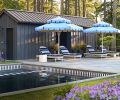 A profusion of Geranium ‘Rozanne’ lines the interior garden area borders, including the spa. The pool house architecture echoes the party barn’s, lit by a Barnhouse Electric Co. light. Massucco Warner adds pops of blue with Santa Barbara umbrellas from Terris Draheim Outdoor playing off blue striped Janus et Cie lawn chairs. Even the pool and spa’s edges reiterate the blue and white striped theme. Bluestone pool coping provides non-slip properties. Green Man sand-set the Pennsylvania Bluestone deck.