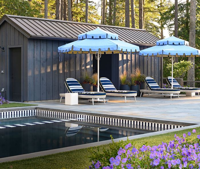 A profusion of Geranium ‘Rozanne’ lines the interior garden area borders, including the spa. The pool house architecture echoes the party barn’s, lit by a Barnhouse Electric Co. light. Massucco Warner adds pops of blue with Santa Barbara umbrellas from Terris Draheim Outdoor playing off blue striped Janus et Cie lawn chairs. Even the pool and spa’s edges reiterate the blue and white striped theme. Bluestone pool coping provides non-slip properties. Green Man sand-set the Pennsylvania Bluestone deck.