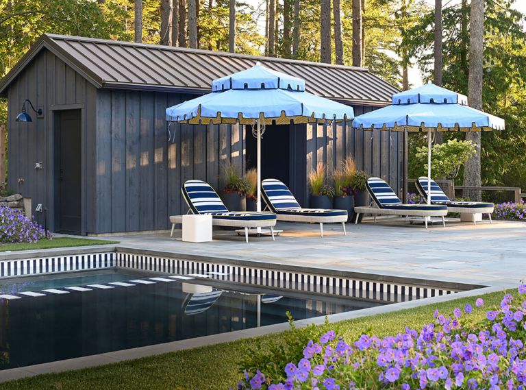 A profusion of Geranium ‘Rozanne’ lines the interior garden area borders, including the spa. The pool house architecture echoes the party barn’s, lit by a Barnhouse Electric Co. light. Massucco Warner adds pops of blue with Santa Barbara umbrellas from Terris Draheim Outdoor playing off blue striped Janus et Cie lawn chairs. Even the pool and spa’s edges reiterate the blue and white striped theme. Bluestone pool coping provides non-slip properties. Green Man sand-set the Pennsylvania Bluestone deck.