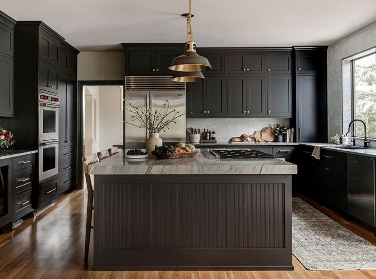 Custom cabinets in Iron Ore from Sherwin Williams prioritize plenty of storage. Their double height makes use of previously dead space at ceiling level. A clever pull-out coffee hub and lower drawers throughout make for easy access and tidy-up. The handmade tile backsplash from Cle Tile adds a bespoke, artisan texture.