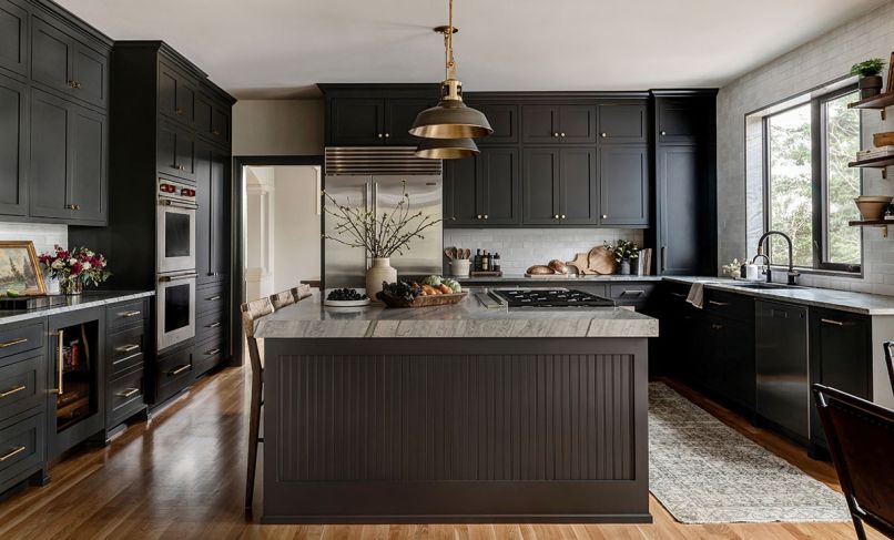 Custom cabinets in Iron Ore from Sherwin Williams prioritize plenty of storage. Their double height makes use of previously dead space at ceiling level. A clever pull-out coffee hub and lower drawers throughout make for easy access and tidy-up. The handmade tile backsplash from Cle Tile adds a bespoke, artisan texture.