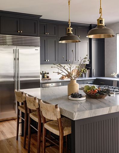 A Sub-Zero fridge, cooktop, and warming drawer are by Wolf. The Leblon Quartzite countertop by Trio Surfaces was the catalyst for the kitchen’s color palette, including the custom cabinets by Superior Cabinets painted a dark Iron Ore. The pendants from Urban Electric are entirely custom, allowing the designer to create a unique piece that complemented the kitchen’s other hardware.