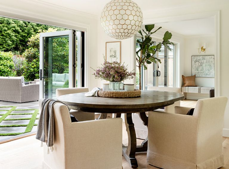 An updated floor plan transformed the dark and choppy ground floor. Andersen Windows & Doors bi-fold glass doors from Windows, Doors & More create two 12-foot openings in dining and living room. A mix of the clients’ furniture and custom pieces blends the contemporary and traditional in every room. The new lighting plan brought much-needed flexibility, including increased overhead lights like this Serena & Lily Chandelier in the dining room.
