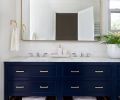 The bathroom features a clever lineup of three prefabricated console bases with a custom dual-sink countertop. Z Collection Carrera marble hex tiles from Contract Furnishings Mart are an example of traditional, durable materials in a contemporary application.