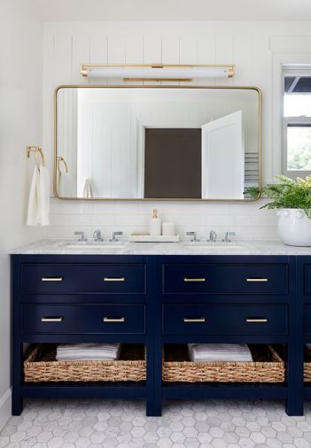 The bathroom features a clever lineup of three prefabricated console bases with a custom dual-sink countertop. Z Collection Carrera marble hex tiles from Contract Furnishings Mart are an example of traditional, durable materials in a contemporary application.