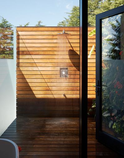 The outdoor shower connected to the primary suite bathroom is another seamless indoor/outdoor moment. Frosted glass on one side fosters privacy, and a clear letterbox window enables views to the water. A living green wall softens the interior, and no ceiling makes it possible to shower under the stars.