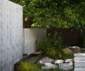 The branches of the heritage tree can freely expand over the concrete wall. A custom metal fountain, made by Dovetail, connects the two courtyards.