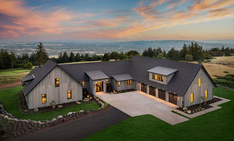 Wrapping the rustic “Hewn” Napa Valley inspired home in Hewn grey cedar siding sets it against lush green landscape and native northwest plantings. Custom double entry doors lit by gas burning lanterns open onto great room with panoramic vista. Black trimmed Marvin windows from Parr Lumber echo four-car garage doors. EV charging station.