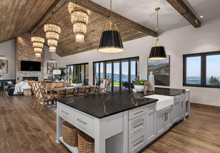 Eye-catching Matrix Varaluz chandeliers from Globe Lighting. Mutual Materials Old University fireplace brick. Hewn tongue and groove spruce ceiling and beams. Gabby Home dining and captain chairs. Four Hands table.