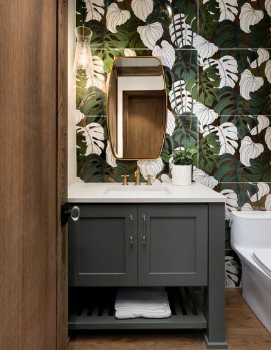 Powder bath’s oversized Tropez Foliage Blanco tile inspired many showgoers. Capital Lighting sconce from Globe Lighting teams with brass-trimmed Uttermost mirror and Brizo plumbing. Fresh Concrete Caesarstone countertop crowns cabinet in Succulent Sherwin Williams.