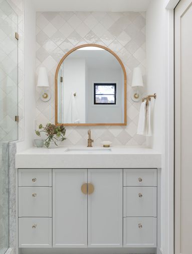In a guest bathroom, the vanity is topped with a Caesarstone counter from Elemar, and has hardware from Inspire Hardware.