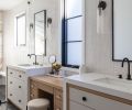 In the primary suite, the custom vanity has the same “white oak frame,” with drawers painted ‘Shaded White’ by Farrow & Ball. The walls are covered in Context Tile, while the floors have Noir Sully honed black limestone, both from Ann Sacks.