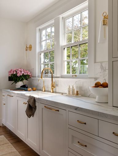 The windows by Stile Windows & Doors, from Windows, Doors & More, are consistent with the original windows in this remodeled Dutch Colonial home. Brass Waterworks sconces and a California Faucets, both from Chown Hardware, sync with cabinet hardware from Rejuvenation.