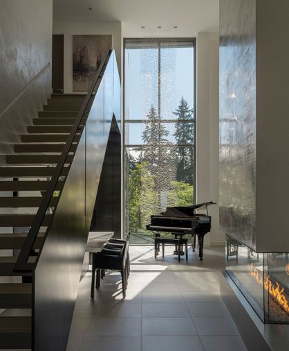 Staircase oak treads, blackened steel handrail and landing fabricated by Evil Metal Works. Piano bar glass fabricated by Stephen Hirt Studios. Daltile Colorbody tile flooring. Anna Skibska added 3' to her existing glass strand sculpture to fit 2-story glass window. Custom Stellar Galaxy fireplace surround, Studio C textured finish.