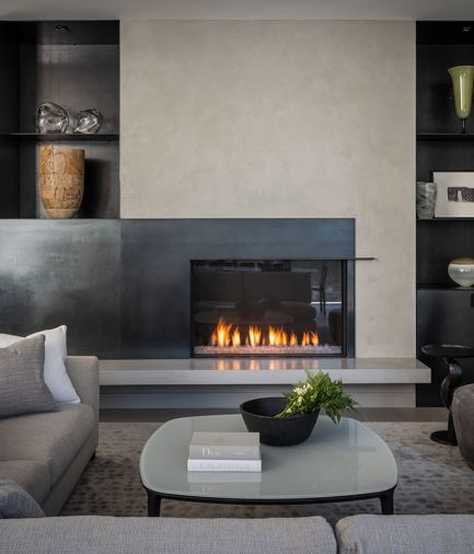 Family room fireplace and surround by Grevstad, fabricated by Decorative Metal Arts. Studio C smooth faced plaster in custom gray. Perennials area rug from Perennials & Sutherland showroom. Gray poured floating concrete hearth, V.C. Studios.