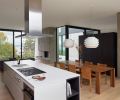 Leicht Seattle brought German-built and engineered kitchen components to nest seamlessly within the open, vaulted living space. The white Neolith island and countertop evoke an altar to cuisine. The range is Wolf, additional appliances are Miele. Ceiling lighting throughout is from Seattle Lighting. The Cassina dining chairs from the owner’s collection perfectly match the Bensen Radii dining table from Inform Interiors.