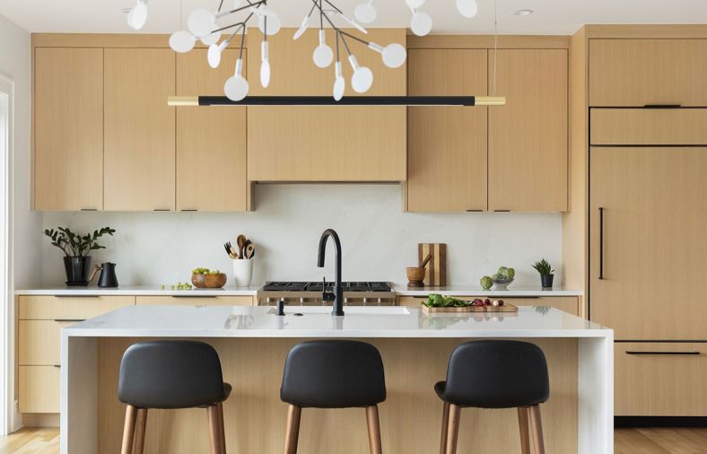 The kitchen is outfitted in custom rift-sawn white oak cabinetry, designed by Wise Design and built by Soren Clark of Owen Gabbert, LLC. Polished Silestone in ‘Calacatta Gold’ from Classique Marble & Granite provides the counter and backsplash.