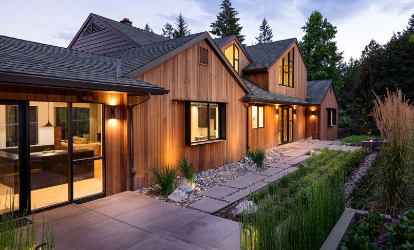 Schouten’s transformed exterior features vertical cedar fine line T&G siding from Lakeside Lumber. Handsome Michael Schultz Landscape Design draws eye to newly designed roof, windows, and dramatic entry illuminated by Oregon Outdoor Lighting.