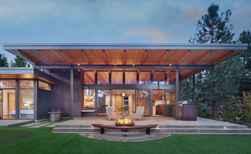 The custom firepit and bench are designed by Studio Zerbey with installation by Western Metal Products, Rodman Construction, and Centerline Artworks. The weathered Corten Steel Panels that frame the outdoor grilling station and provide privacy to the adjacent bedroom match the fireplace mantel in the great room.