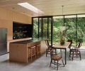 Designed by GO C and built by Sparrow Woodworks the custom cabinetry nestles appliances from Albert Lee. Douglas Fir shelving above the sink was milled on-site and ebony stained.