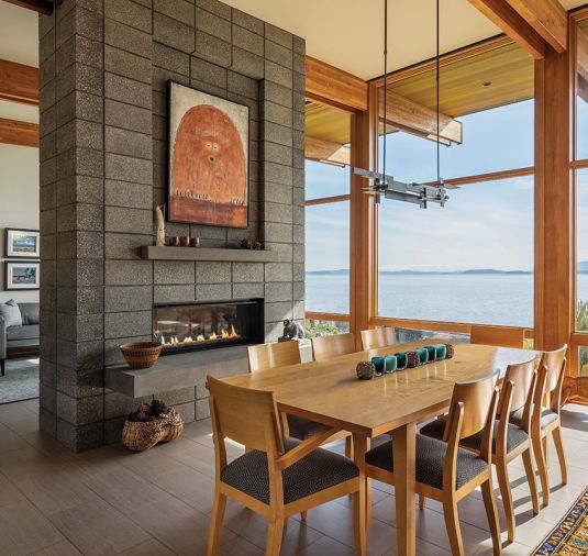The exposed glulam beams and columns are from Westside Building Supply. CMU block forms the fireplace, while porcelain floor tile by Architectural Surfaces from SVC Interiors & Design Inc covers the floor.
