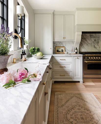 Benjamin Moore White Dove and Classic Gray paint delivers warmth in homage to European country design. The custom range hood features sculptural corbel legs that beautifully frame the Ilve Italian range.