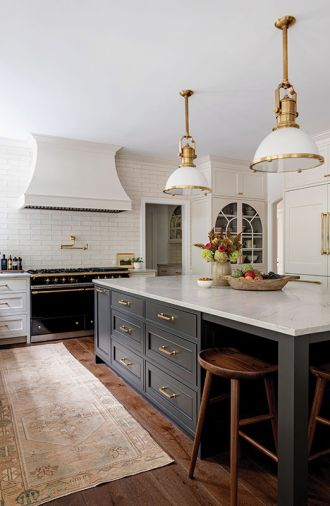 The island provides a large work surface with ample storage within arm’s reach of the refrigerator. Tractor seat stools from Rejuvenation complement the dark wood floor and can tuck entirely under the counter.