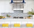 A pop of yellow from Lee Industries stools from J Garner Home. Architectural Stonewerks island counter fabrication with Ann Sacks backsplash and Urban Electric Co. pendants. Studio AM Architects & Interiors designed a new range hood and replicated existing cabinets in the island unit.