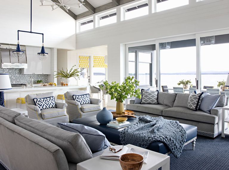 Benjamin Moore Simply White brightens the space. Massucco Warner custom Schumacher window treatments and O. Henry House sofas and chairs with yellow piping from Kelley Forslund Showroom (SDC). Made Goods side tables from J Garner Home. Custom leather ottoman from Massucco Warner and a Holland & Sherry area rug (SDC).