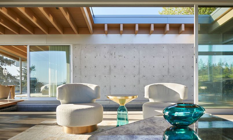 Custom chairs, coffee table and sectional are by Garret Cord Werner Architects and Interior Designers. Picking up the crisp blue of the water, an elegant Bell Side Table with aqua glass bottom and gold inverted cylinder from Inform Interiors.