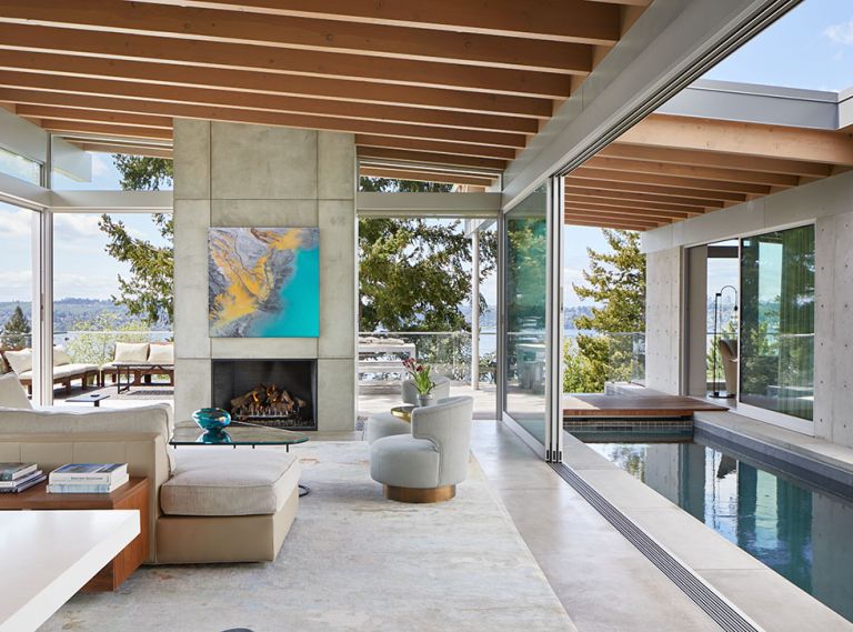 Fleetwood doors and windows throughout are from Goldfinch, and foster a fluid connection between inside and out, with glass panels even pocketing into the concrete fireplace column. Outdoor sofas, coffee table, table and benches are from Janus et Cie.