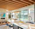 The upper floor has polished concrete flooring with radiant heating throughout, with overhead lighting by Kichler Lighting tucked into the fir and cedar ceiling. The kitchen bar stools are custom by Garret Cord Werner Architects and Interior Designers. The clean design and natural light create an airy, welcoming space.