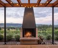 The dwelling arises as a part of the terrain, the centerpiece is a large outdoor fireplace custom-built on-site.
