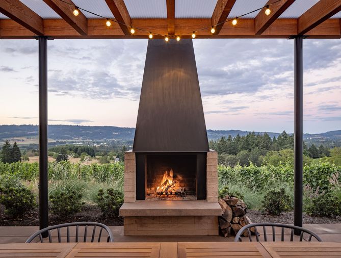 The dwelling arises as a part of the terrain, the centerpiece is a large outdoor fireplace custom-built on-site.