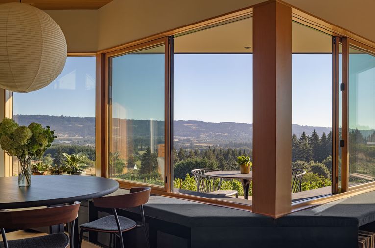 Inside and outside dining areas sit in tandem across a corner of glazing outfitted with a custom built-in storage bench, which houses the homeowner’s extensive record collection.