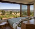 The master bedroom features beautiful and practical built-in storage and master bed by Big Branch Woodworking. The bed is flush with the wall and aligned to the windows to give the sleeper a sense of floating in the vines.