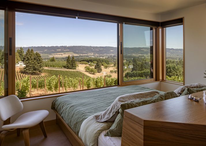 The master bedroom features beautiful and practical built-in storage and master bed by Big Branch Woodworking. The bed is flush with the wall and aligned to the windows to give the sleeper a sense of floating in the vines.
