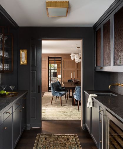 Butler’s pantry illuminated by Halcyon sconce and Hudson Valley Middlebury Flush Mount lighting. A GE Monogram wine fridge is tucked under Mely Gray limestone counters.