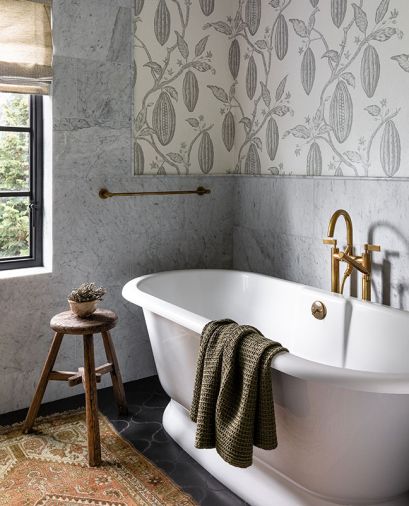 The tub area features a Vervain wallcovering, Bedrosians Carrara honed marble wall and a Victoria & Albert Traditional Double-Ended tub.
