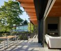 A Weiland 32-foot lift and slide door by Andersen connects the living spaces to the exterior deck, as does the seamless porcelain floor covering. The lumber throughout was provided by Lindal Cedar Homes, while the exterior dining table was built by Schaefer Construction.