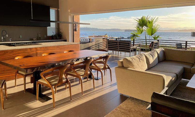 At the center of the room, the live-edge table was designed by OTO Design and built by Schaefer Construction. Lighting design by OTO Design, with fixtures sourced from Seattle Lighting.