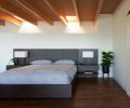 In the primary bedroom, operable skylights over the staircase circulate air and bring in light. The bedside lamps are from Seattle Lighting, while the walnut flooring is from California Hardwoods.