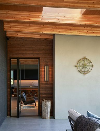At the entry, a private patio with the same porcelain flooring as inside, and a Windsor pivot entry door, blurs boundaries between inside and out.
