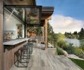 An awning window with gas struts from Central Glass & Aluminum in Australia opens to an exterior concrete serving and dining counter, fabricated by local company Cement Elegance. The stools are from Terra Outdoor Living.