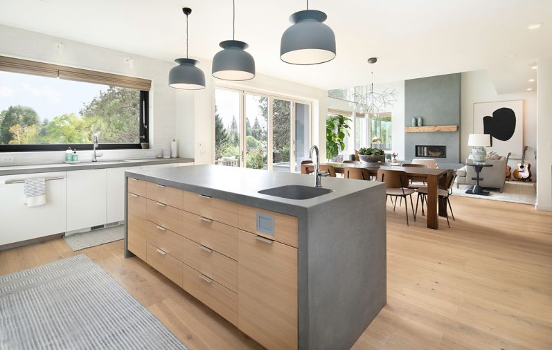 The kitchen’s concrete counters sync with the cement surround and hearth in the living room, both from Cement Elegance. The rift-cut white oak flooring throughout is from Castle Bespoke.